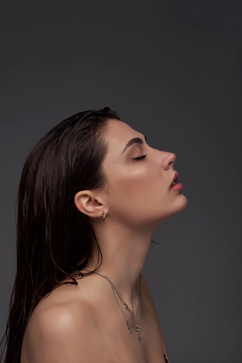 beautiful-black-hair-woman-beautiful-portrait-hairstyle-wet-hair-gray-wall